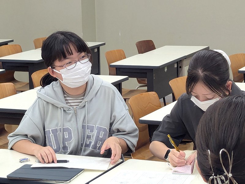 看護師の話に聞き入る学生とメモを取る学生