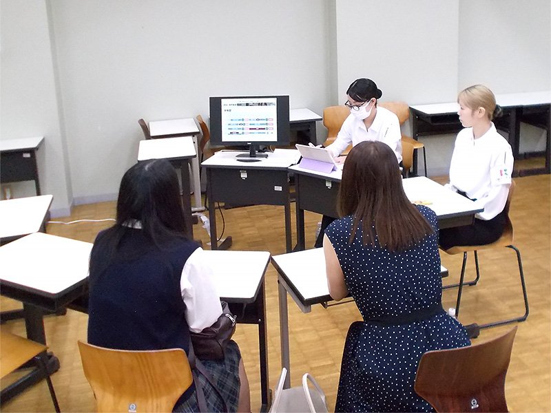 モニタを使って説明をする在学生