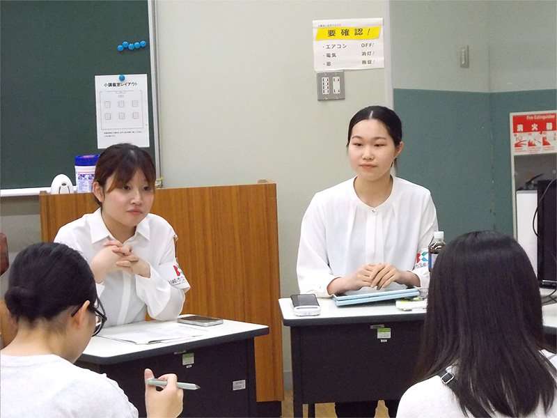参加者の質問を聞く在学生